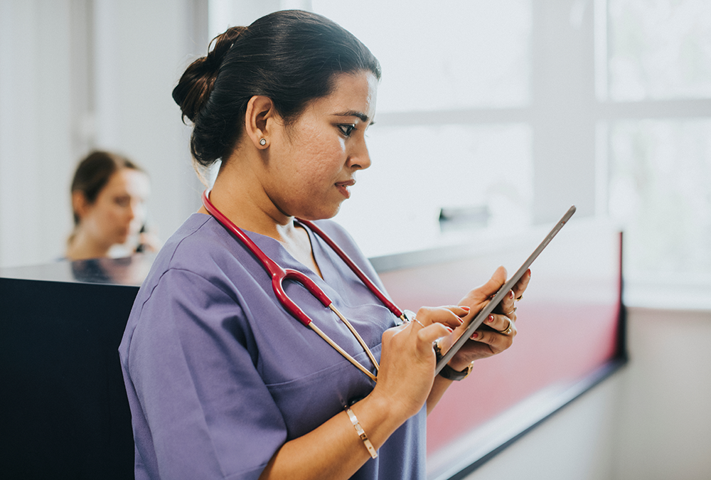 Image of a nurse using a HIPAA-compliant messaging app to communicate with co-workers